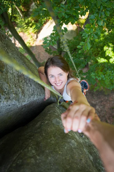 Rockclimber pomaga kobiece wspinacz aby dotrzeć do góry — Zdjęcie stockowe