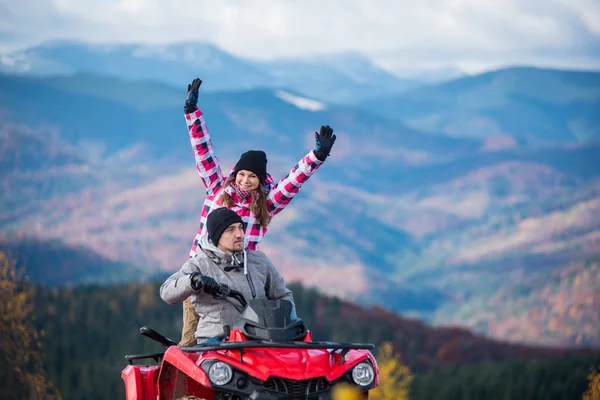 Casal em quatro rodas ATV em montanhas — Fotografia de Stock
