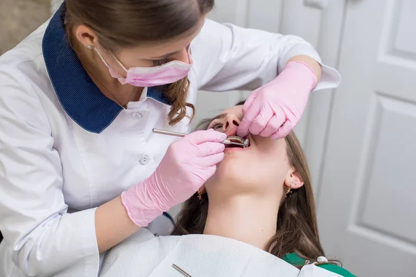 Une dentiste vérifie les dents des patients — Photo