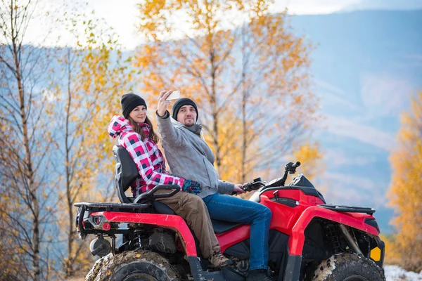 Casal em quatro rodas ATV em montanhas — Fotografia de Stock