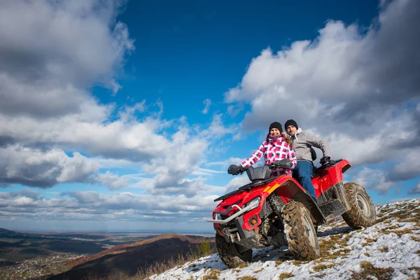 Pareja en ATV de cuatro ruedas en las montañas — Foto de Stock