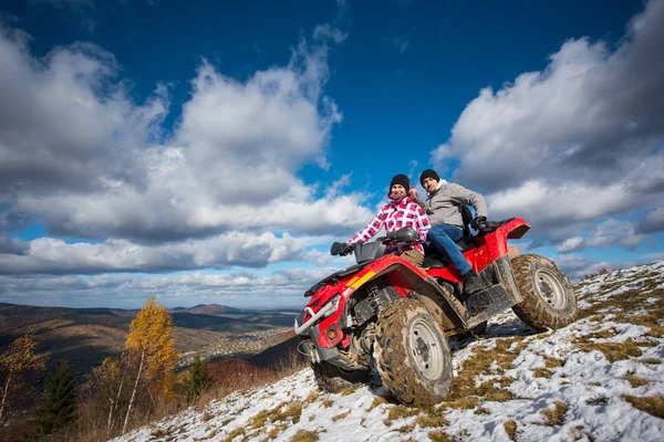 Pareja en ATV de cuatro ruedas en las montañas — Foto de Stock