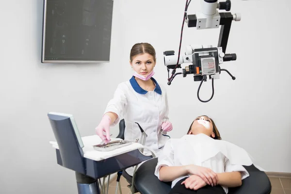 Giovane dentista femminile con donna in clinica — Foto Stock