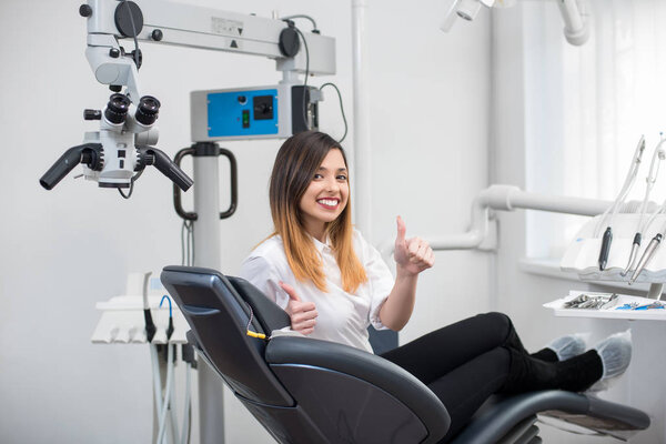 patient  in dental chair showing thumbs up 