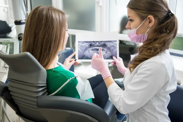 Female dentist and patient examining x-ray — Stock Photo, Image