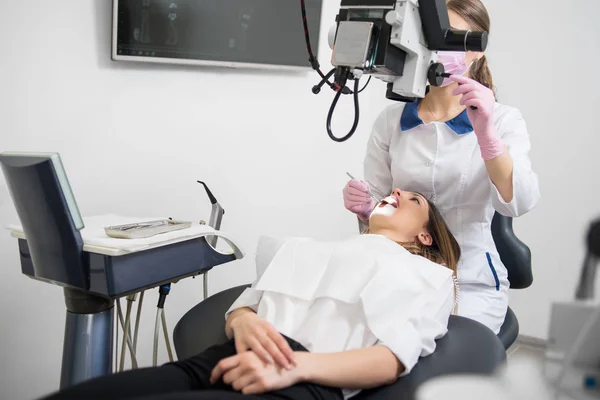 Female dentist  treating patient teeth