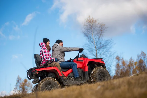 Pareja en ATV de cuatro ruedas en las montañas — Foto de Stock