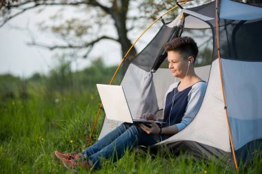 kamp yaparken onu laptop kullanan kadın 