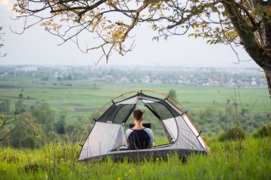 onu laptop kullanarak bir çadırda oturan kadın 