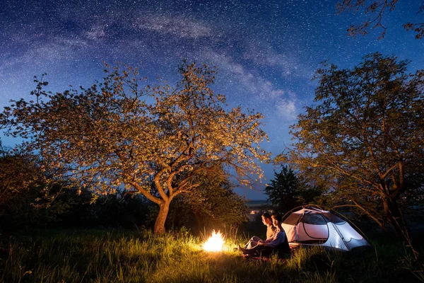 Turistas casal em uma fogueira perto da tenda — Fotografia de Stock