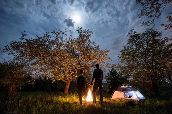 Turistas casal em uma fogueira perto da tenda — Fotografia de Stock