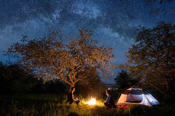 Turistas casal em uma fogueira perto da tenda — Fotografia de Stock