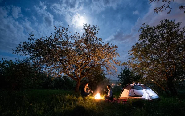 Couple de touristes à un feu de camp près de la tente — Photo