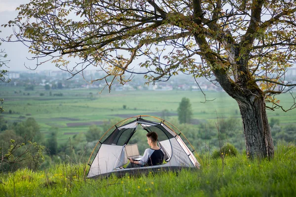 onu laptop kullanarak bir çadırda oturan kadın 