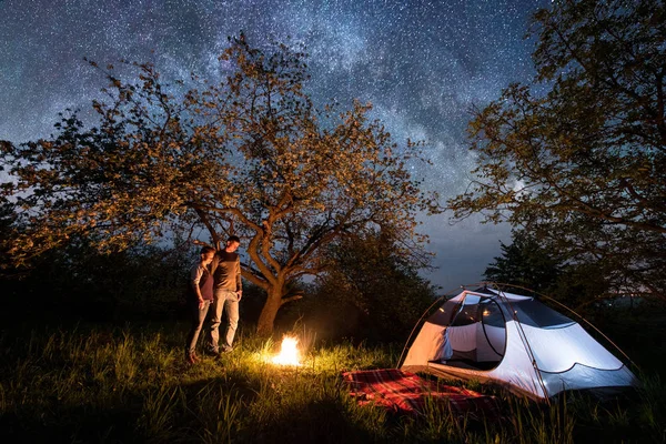 Turistas casal em uma fogueira perto da tenda — Fotografia de Stock