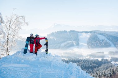 bir dağın tepesinde snowboard