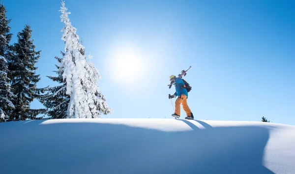 Esquiador masculino caminhando no topo da montanha — Fotografia de Stock