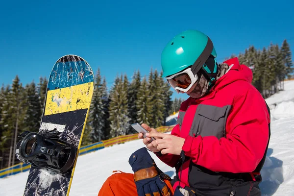 Snowboarder χρησιμοποιώντας το έξυπνο τηλέφωνο — Φωτογραφία Αρχείου