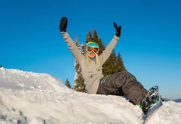 Snowboardista žena sedí na vrcholu svahu — Stock fotografie