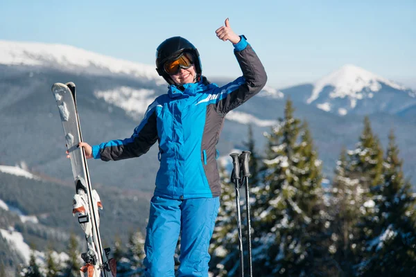 Gelukkig vrouwtje dragen skiën versnelling glimlachen — Stockfoto