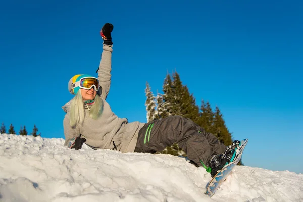 Dívka snowboardista sedí na vrcholu svahu — Stock fotografie