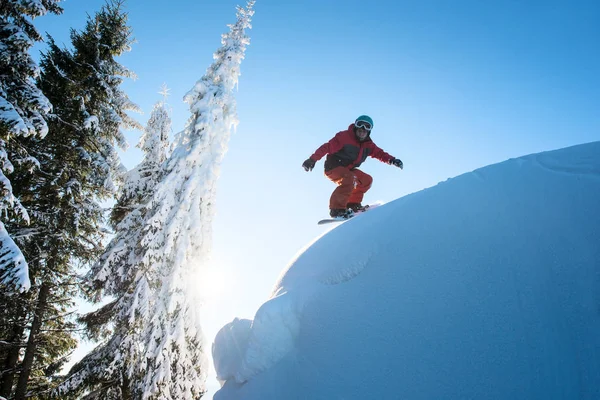 Tehlikeli yamaçta sürme Freeride snowboarder.