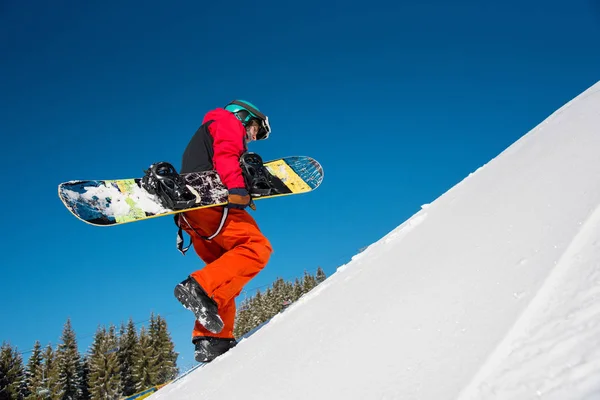 Snowboarder caminando por la pendiente — Foto de Stock