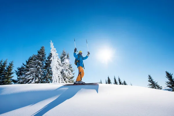 Skifahrer hält Skistöcke in die Höhe — Stockfoto