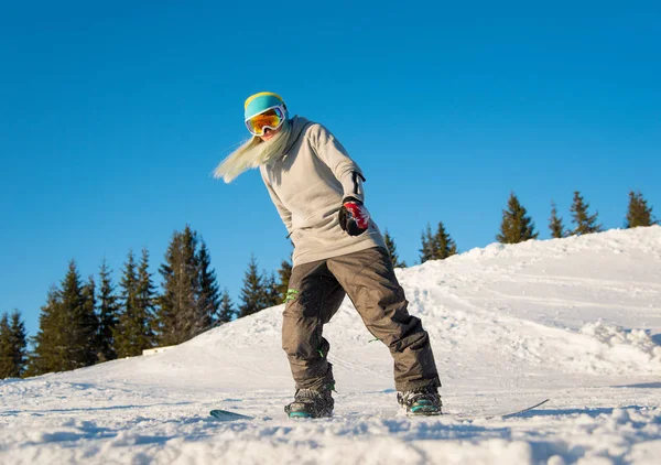 Snowboarder femenino cabalgando en las montañas —  Fotos de Stock