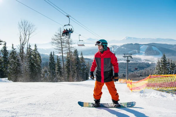 Hombre de pie sobre su tabla de snowboard —  Fotos de Stock