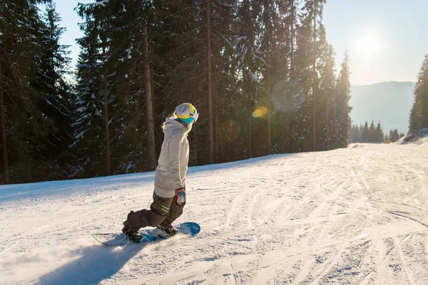 Genç kadın yamaçta snowboard 