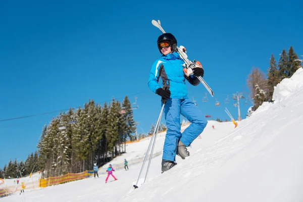 Skifahrerin trägt ihre Skier auf der Schulter — Stockfoto