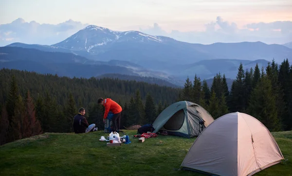 Turistas perto de duas tendas nas montanhas — Fotografia de Stock