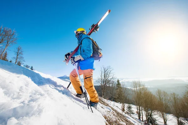 Male skier walking up the slope — Stock Photo, Image