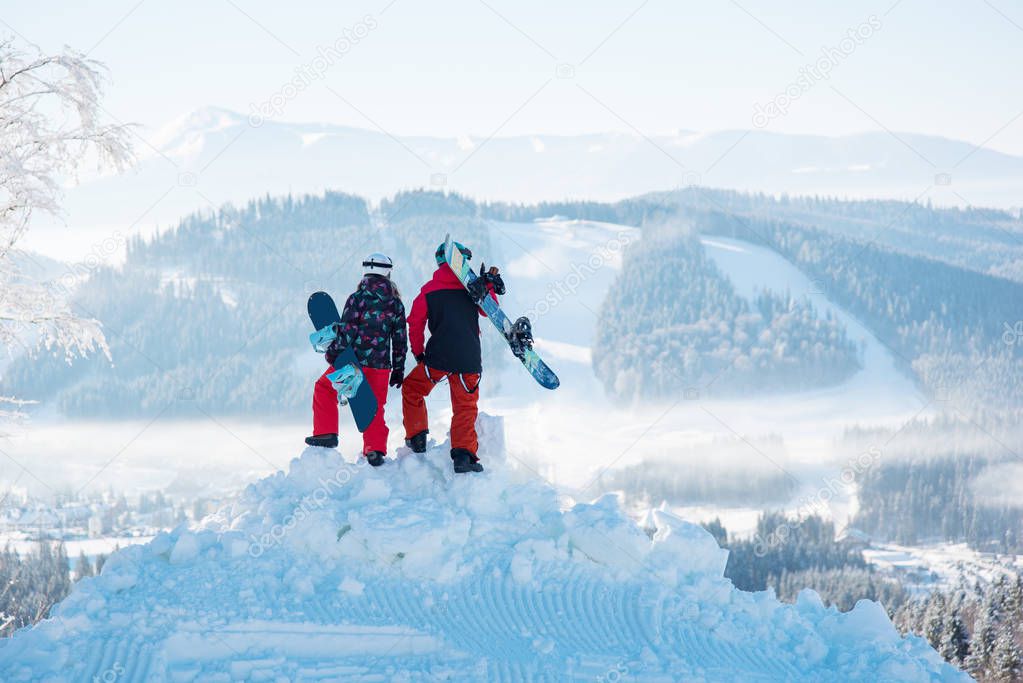 snowboarders on top of a mountain