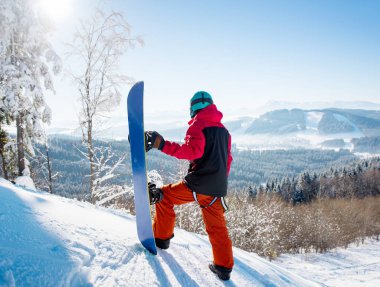 bir yamaç üzerinde duran snowboarder 