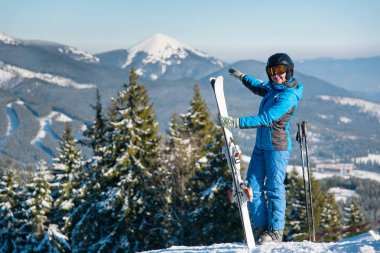 bir dağın tepesinde duran kayakçı 