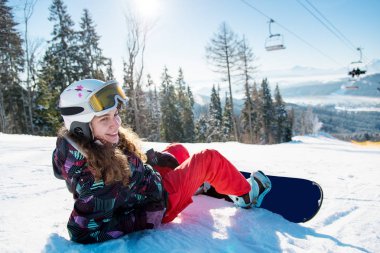 Gülümseyen kadın snowboard kar üzerinde yalan