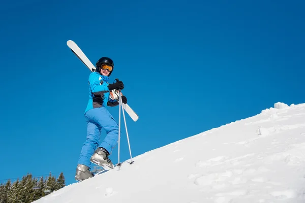 彼女のスキーを運ぶ女性スキーヤー — ストック写真