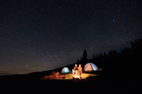 Un par de turistas acampando por la noche — Foto de Stock