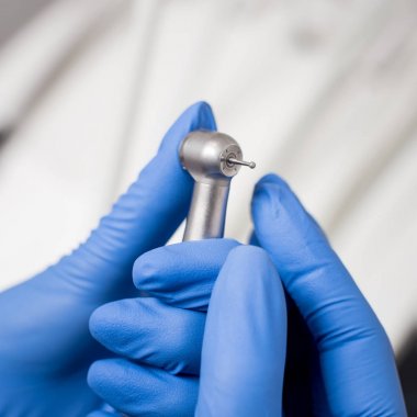 Mavi eldiven diş matkap diş ofisteki çalımakta dişçi elle. Yakın çekim