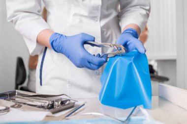 Eldivenli ellerle dişçi diş diş office araçlarında ile çalışıyor. Yakın, seçici odak. Diş Hekimliği