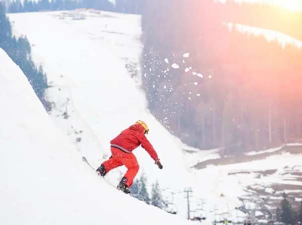 Snowboarder montar desde la cima de la colina nevada — Foto de Stock