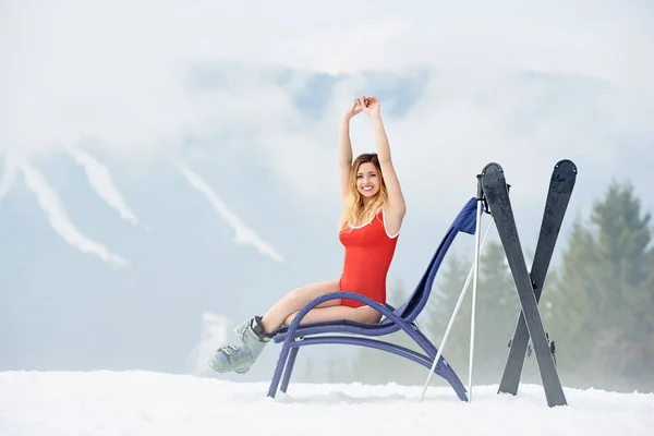 female skier resting on deck chair
