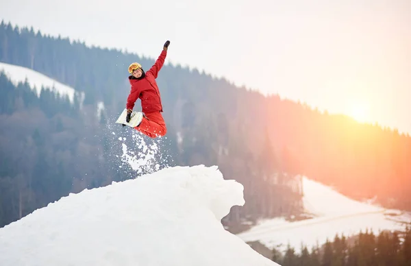 Snowboarder springt auf verschneite Schanze — Stockfoto