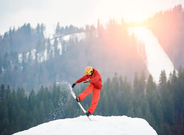 Snowboarder springen op besneeuwde heuvel — Stockfoto