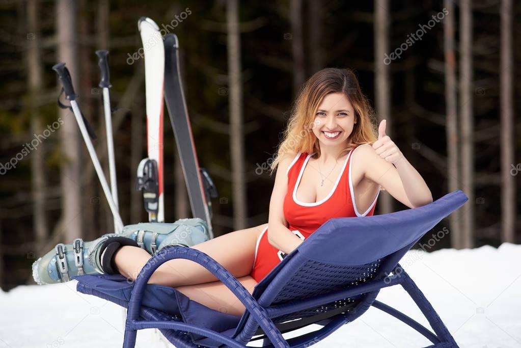 girl sitting on hill with ski equipment