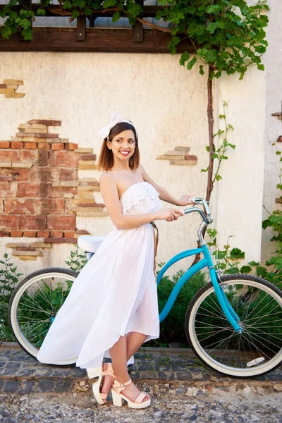 幸せな若い女笑顔と旧市街の観光を楽しむ自転車の近くに立って — ストック写真