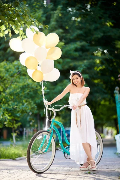 Pozytywne Atrakcyjna Brunetka Białej Sukni Stojącej Pobliżu Niebieski Rower Kolorowych — Zdjęcie stockowe