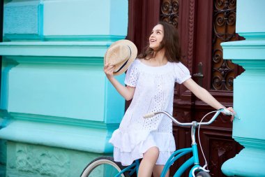 Yatay bir bisiklet eski bir şehir gezi sırasında oturan mutlu genç esmer güzel bir kadın portresi